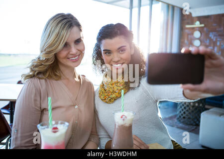 Female friends taking a selfie on mobile phone Stock Photo