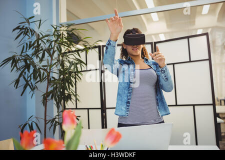 Businesswoman gesturing while using virtual reality headset Stock Photo