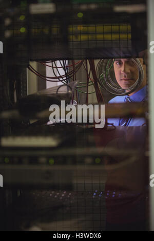 Technician checking cables in a rack mounted server Stock Photo