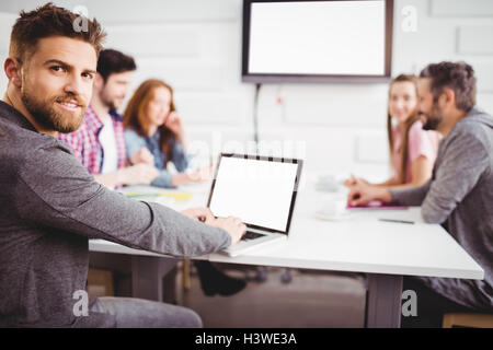 Portrait of confident executive using laptop at meeting room Stock Photo