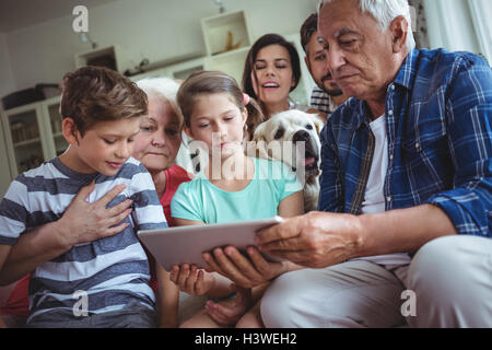 Multi-generation family using digital tablet in living room Stock Photo