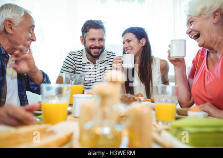 Happy couple and parents talking while having breakfast Stock Photo