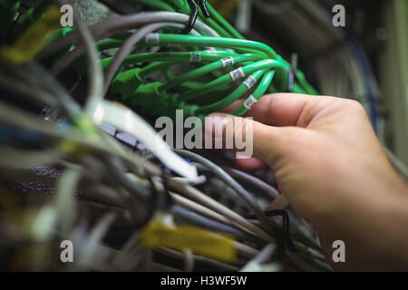 Technician plugging patch cable in a rack mounted server Stock Photo