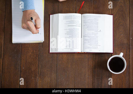 Man with a bible writing on notepad Stock Photo