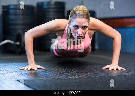 Determined woman doing push-ups Stock Photo