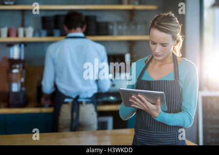 Waitress using digital tablet at counter Stock Photo