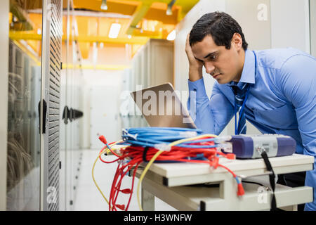 Stressed technician using laptop Stock Photo
