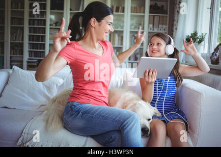 Excited mother and daughter using digital tablet and dancing Stock Photo