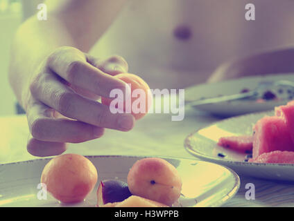 Young woman eating plums and watermelon Stock Photo