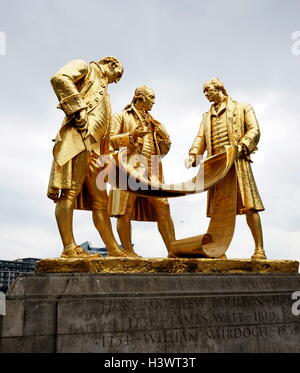 Gold statue titled 'Boulton, Murdoch and Watt' by William Bloye (1890-1975) an English sculptor. The statue is of three of Birmingham's most famous figures; Matthew Boulton (1728-1809), William Murdoch (1754-1839), and James Watt (1736-1819). Dated 20th Century Stock Photo