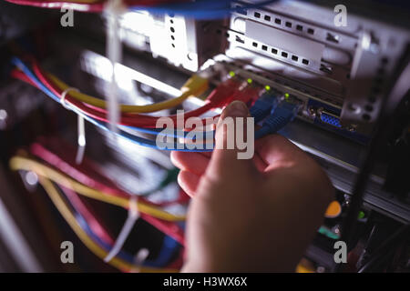 Close-Up of technician plugging patch cable in a rack mounted server Stock Photo