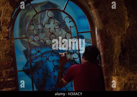 Assiut, Egypt. 11th Oct, 2016. A man prays at the Cave Church inside Convent of Virgin Mary which is believed to be the last stop of the Holy Family in Upper Egypt, in Dronka town of Assiut, Egypt, Oct. 11, 2016. The Monastery of Virgin Mary at Al-Muharraq and the Convent of Virgin Mary on the Mountain of Assiut province in southern Egypt stand as historical eyewitnesses of the flee trip of the Holy Family of Jesus Christ, his mother Virgin Mary and St. Joseph to Upper Egypt over 2,000 years ago. © Meng Tao/Xinhua/Alamy Live News Stock Photo