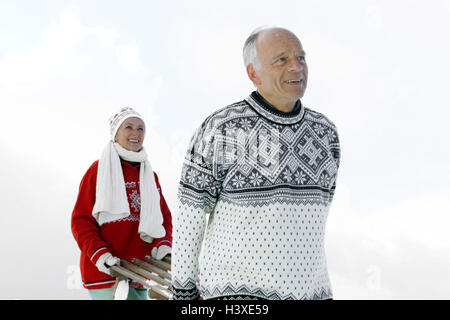 Senior couple, happy, slides, carry, winters, senior citizens, couple, old person, Best Age, happy, agile, vital, sportily, motion, excursion, enterprising, walk, go for of a walk, sleigh-riding, sledge, wooden slide, together, snow scenery, clothes, wint Stock Photo