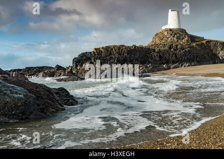 Waves on the beach below Llanddwyn lighthouse Stock Photo