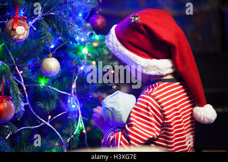 Cute little boy, decorating christmas tree at night Stock Photo