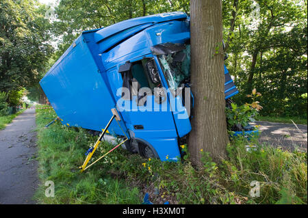 A truck crashed against a tree on a small road outside the city. Stock Photo