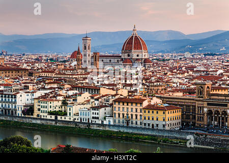 Elevated look at Florence city downtown dominated by Santa Maria Del Fiore cathedral designed by Michelangelo on Arno river. Stock Photo