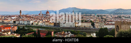 panorama of Florence city downtown at sunrise against distant hills from elevated lookout over Arno river to historic landmarks Stock Photo