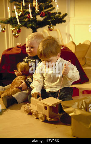 Christmas, sitting rooms, children, Christmas presents, teddy bear, locomotive, plays inside, at home, distribution presents, boy, infants, two, present, Christmas present, toys, Teddy, railway, wooden toys, train, joy, game Stock Photo