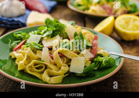 Tagliatelle with bacon, garlic and salad, homemade pasta from best italian flour - semolina Stock Photo