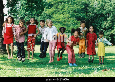 Meadow, children, group, skin colour differently, caper, fun, summer, outside youth, childhood, friends, friendship, boy, girl, hand in hand, nationality, passed away, difference, game, leisure time, amusement, melted, lighthearted, jump, play, crack Stock Photo