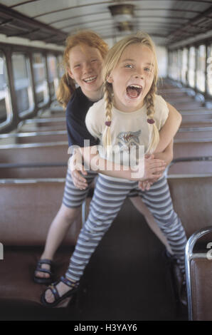 Train compartment, girl, happy, embrace, detail, inside, summer, vacation, holidays, leisure time, childhood, children, 9 years, fun, rave, romp, shout, shout, excursion, travel, train travel, train journey, trajectory, railway car, carriage, laugh, amuse Stock Photo