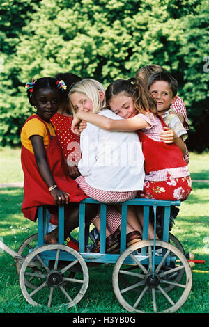 Handcarts, children, group, skin colour differently, summer, outside, garden, childhood, friends, embrace, embrace, friendship, boy, girl, nationality, passed away, multicultural, game, fun, leisure time, carriage, conductor carriage, cart, sit, play, tog Stock Photo