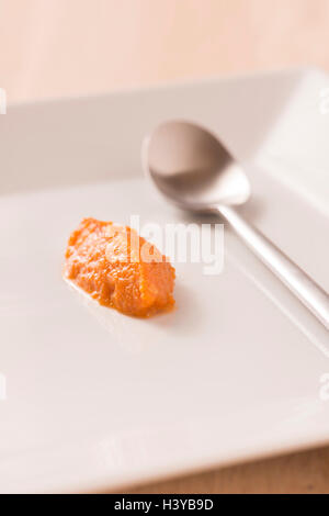 Homemade chili paste on white plate in close up. Stock Photo