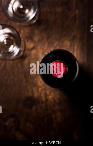 Bottle of red wine and two glasses on wooden table. Top view with copy space. Stock Photo