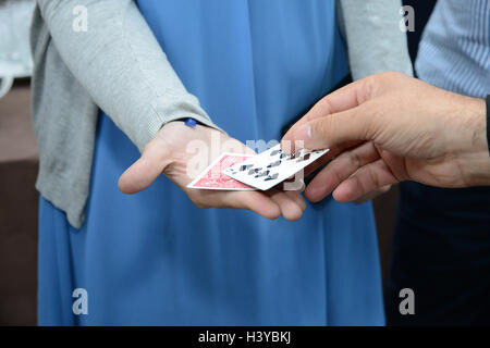 Close up of a magician performing a magic trick using cards Stock Photo