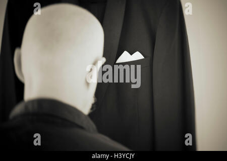 Old man dressing in formal dress. Rear view portrait. Lifestyle moment of retired person. Stock Photo