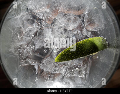 A gin and tonic in a bar with a slice of lime Stock Photo