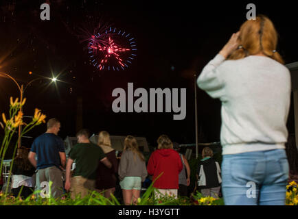 4th of July revelers watch a fireworks display over downtown Fitchburg, Massachusetts Stock Photo