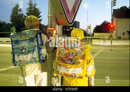 Street, traffic light, children, school way, back view, daybreak town, traffic, traffic, road safety, schoolboy, school children, school beginners, atomic, biological and chemical protection, two, schoolbags, reflectors, stand, touch of a button, signal r Stock Photo
