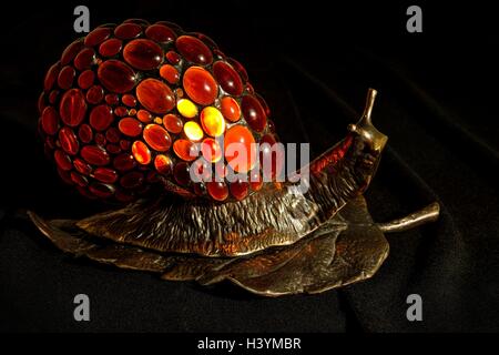 Handmade lamp in the form of a snail made of bronze and natural Baltic amber Stock Photo