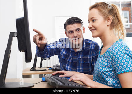Man Training Woman On Computer In Office Stock Photo