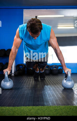 Man doing push-ups with kettlebell Stock Photo