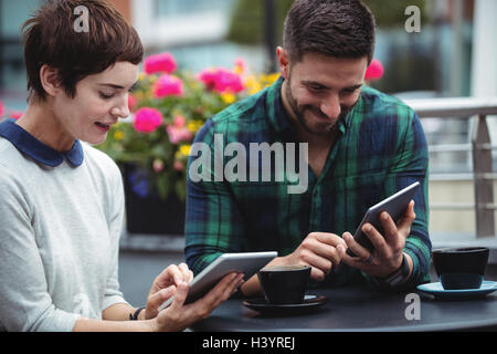 Businesspeople using digital tablet while having coffee Stock Photo
