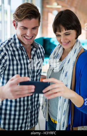 Smiling couple looking at the mobile phone Stock Photo