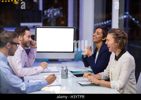 Businesspeople interacting with each other in conference room Stock Photo