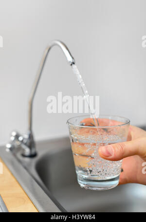Filling glass with filtered water Stock Photo