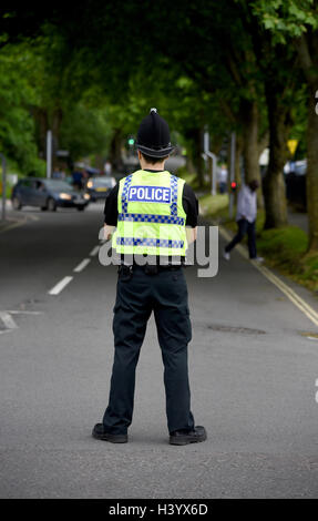 Rear view of a British Police officer wearing a bullet proof vest ...
