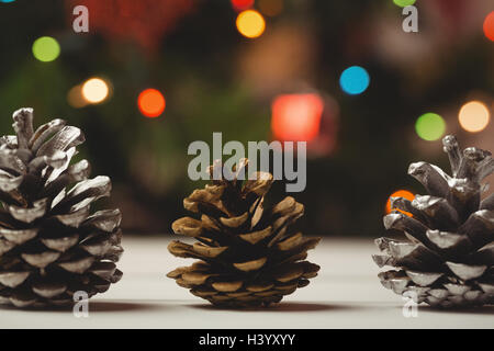 Three pine cones on wooden table Stock Photo