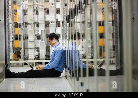 Technician working on laptop in hallway Stock Photo