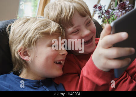 Close-up of happy brothers using digital tablet at home Stock Photo