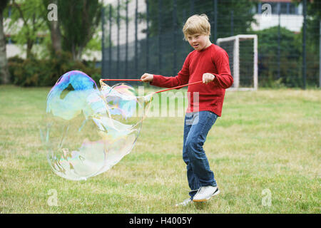 Disabled boy playing with soap bubbles in park Stock Photo