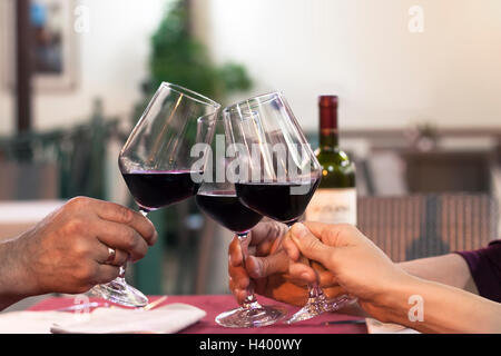 Group of friend clinking glasses of wine in a restaurant Stock Photo