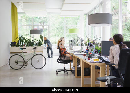 Business people working in brightly lit creative office Stock Photo