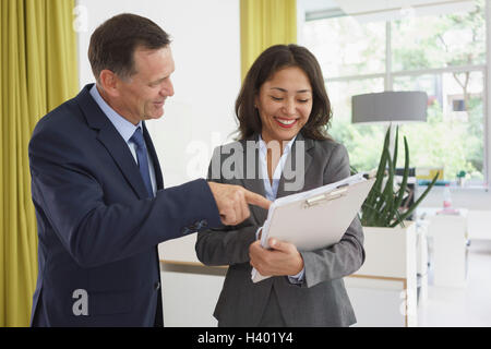 Happy business colleagues discussing over documents in creative office Stock Photo