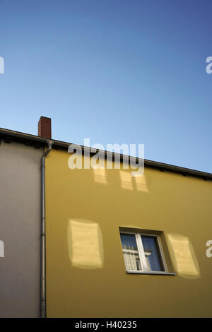 Low angle view of yellow residential building against clear blue sky Stock Photo